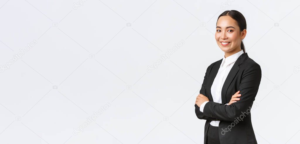 Professional young asian female entrepreneur, real eastate agent in suit cross arms and looking confident at camera. Successful businesswoman leading business. Team lead starting meeting