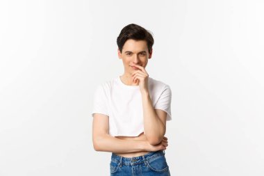 Lgbtq ve gurur konsepti. Tatmin olmuş genç eşcinsel bir adam, bir fikre sahip olmak ve kameraya bakarken gülümsemek, ekşi bluz, beyaz arka plan