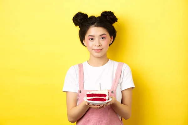 Ασιατικό κορίτσι γενεθλίων στέκεται με τούρτα και χαμογελώντας, γιορτάζει b-day σε κίτρινο φόντο — Φωτογραφία Αρχείου