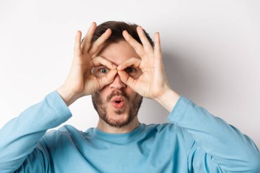 Etkilenmiş beyaz adam, hayretler içinde el dürbününden bakıyor, 