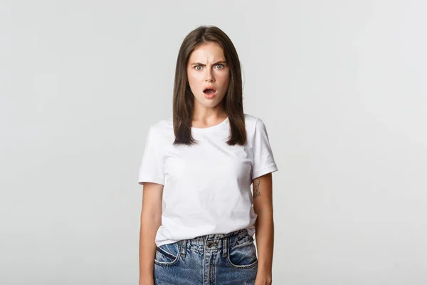 Portrait of horrified and shocked young woman gasping and frowning frustrated, looking offended — Stock Photo, Image