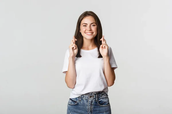 Hopeful smiling girl cross fingers good luck, making wish or praying — Stock Photo, Image