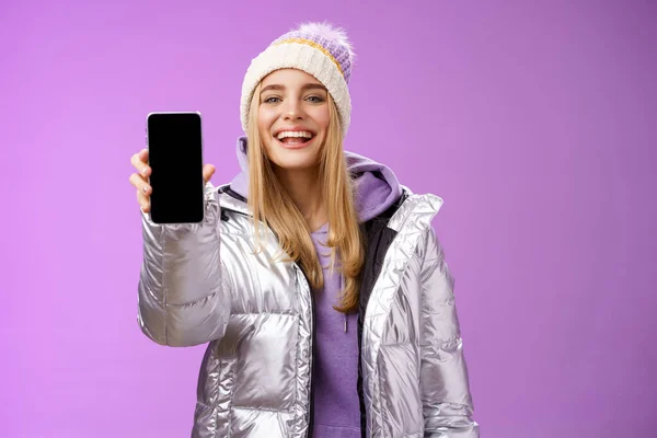 Frech erfreut fröhliche blonde Frau empfehlen Verwendung App bearbeiten perfekte Bilder halten Smartphone zeigt Handy-Display stolz zufriedenstellend Lächeln Kamera, stehend lila Hintergrund — Stockfoto