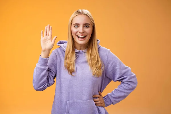 Φιλική ενεργοποιημένη χρήσιμη γοητευτική μαθήτρια λέει γεια νεοφερμένοι χαιρετώντας έθεσε παλάμη Γεια χειρονομία χαιρετισμό καλωσορίζοντας ευτυχώς, στέκεται πορτοκαλί φόντο χαμογελώντας ευρέως — Φωτογραφία Αρχείου