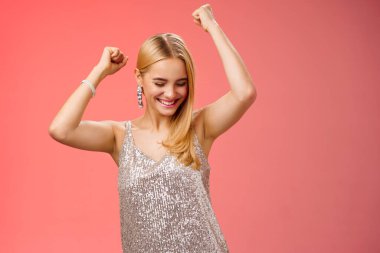 Joyful blond excited birthday girl having fun carefree dancing raised hands close eyes smiling enjoying night-out girlfriend nightclub have fun standing amused red background entertained clipart