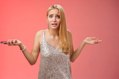 Hüsrana uğramış, terk edilmiş, sarışın, çekici kız arkadaşı omuz silkiyor. Sorgulanmış gibi görünebilir. Sorgulanmış, bilgisiz.