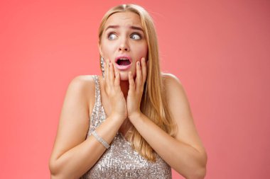 Korkmuş kız paniği korkmuş, korkudan titreyen, güvensiz, yanaklara dokunan, yan yan bakan, soluk soluğa kalmış korkmuş, gergin bir şekilde bekleyen yardım bekleyen, endişeli kırmızı arka plan.