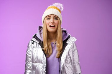 Upset sobbing miserable cute blond woman in silver stylish jacket hat crying whining unhappy feel sadness distress look disappointed complaining cruel life, unlucky standing purple background clipart