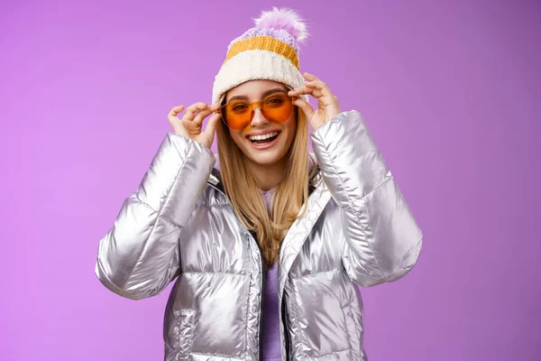 Good-looking charming happy smiling blond girlfriend having fun vacation girlfriends put on sunglasses grinning delighted wear cool silver glittering jacket warm winter hat, purple background — Stock Photo, Image