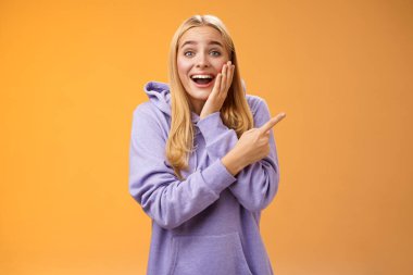 Heyecanlı, dilsiz, mutlu, kapüşonlu 25 'lik sarışın kadın. Şansın yaver gittiğine inanamıyor.