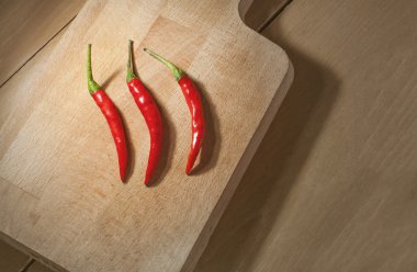 Natürmort ahşap arka plan üzerinde kırmızı Tay Chili. Karanlık sıcak vintag