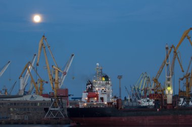 Odessa, Ukrayna - Ağustos 2016: gemi boşaltma limanında dolunay altında terminal akşam Vinçler kapsayıcılar ve demiryolu vagonlar ile.