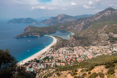 Türkiye 'nin güneybatısındaki Oludeniz, Fethiye, Turkuaz sahillerindeki mavi göl ve kumsal panoramik hava manzarası. Oludeniz 'de güneşli ve açık mavi gökyüzü.