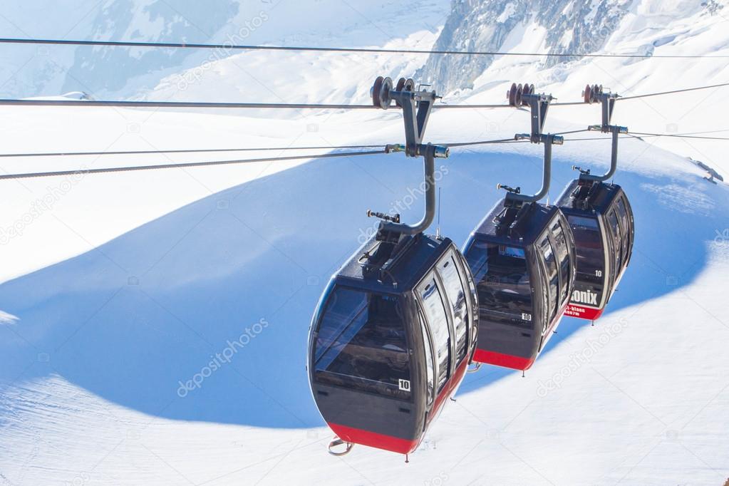 Cabins of cable-way against white glacier in the mountain, Alps