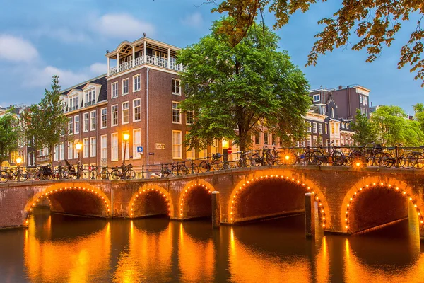 Gece şehir manzaralı, Amsterdam kanal, tipik Hollanda evleri ve tekneler, Hollanda.