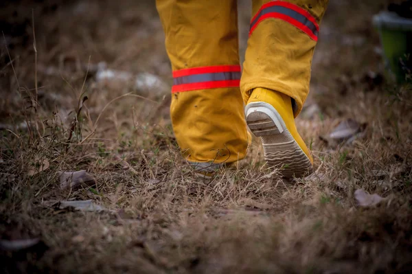Пожежний костюм, що йде по траві — стокове фото