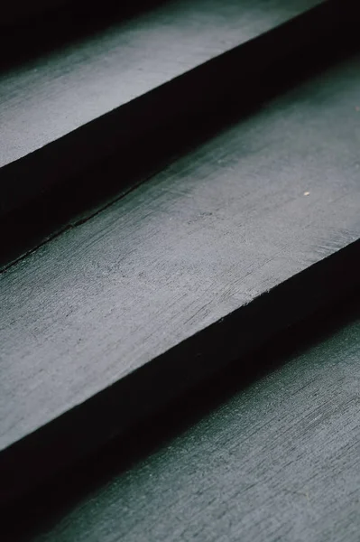 Güçlü çizgileri olan gölgeli siyah merdivenler, derin tabanlı çapraz kompozisyon, mat bitiş, yüksek kontrast