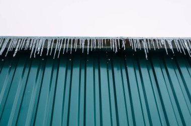 Oluklu Metal Çatı Keskin Buz Sarkıtları, Yeşil Paneller Açık Buz ve Mimari Kontrastlı