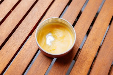 Geniş Ev Yapımı Kozmetik Kremi 'nin Dokulu Kırsal Ahşap Yüzey Üzerine Detaylı Görünümü