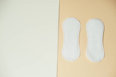 Bej yüzeyde Emici Pedlerin Ürün Fotoğrafı Gösterimi Dokuları Vurguluyor