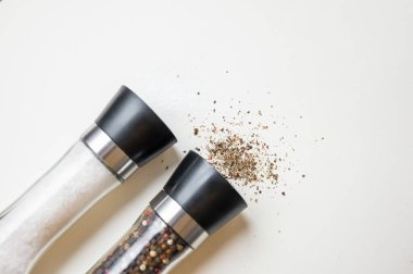 Tuz ve Biber Değirmenleri Dökülmüş Biber ve Tuz Kristalleri Beyaz Yüzeyde