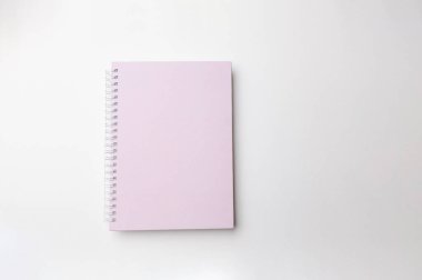 Beyaz yüzeyde pembe sarmal defter, yumuşak gölgeli ve temiz başlık kompozisyonu