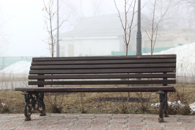 koyu ahşap Bank sokakta üzerinde duruyor