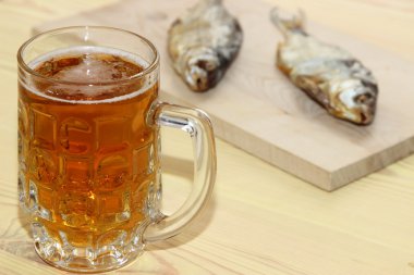 Masanın üzerinde bir çiğ balık ile hafif bira