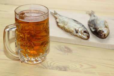 Masanın üzerinde bir çiğ balık ile hafif bira