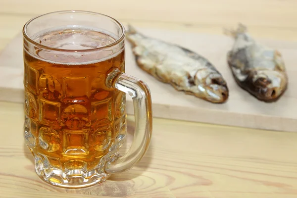 Светлое пиво с соленой рыбой на столе — стоковое фото