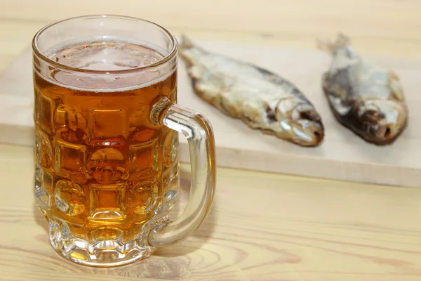 Masanın üzerinde bir çiğ balık ile hafif bira