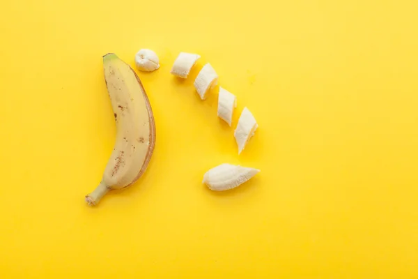 Peel banana and fruit on a yellow background — Stock Photo, Image