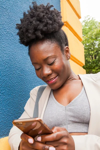 एक स्मार्टफ़ोन के साथ युवा अफ्रीकी महिला — स्टॉक फ़ोटो, इमेज