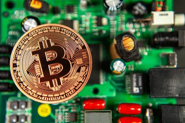 Bitcoin sikkelerinin fotoğrafı bir anakart madencilik madeni paralarının üzerinde renkli bir zemindeki kripto para piyasasını sembolize ediyor.