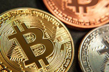 Bitcoin sikkelerinin fotoğrafı, insanlar olmadan ve renkli bir arkaplanda kripto para piyasasını sembolize ediyor.