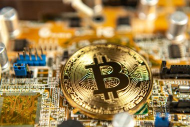 Bitcoin sikkelerinin fotoğrafı bir anakart madencilik madeni paralarının üzerinde renkli bir zemindeki kripto para piyasasını sembolize ediyor.