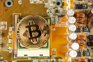 Bitcoin sikkelerinin fotoğrafı bir anakart madencilik madeni paralarının üzerinde renkli bir zemindeki kripto para piyasasını sembolize ediyor.