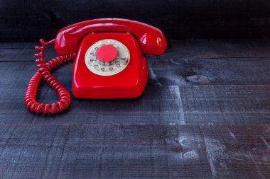Ahşap arka plan üzerinde kırmızı retro telefon