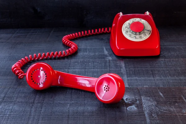 Ahşap arka plan üzerinde kırmızı retro telefon — Stok fotoğraf