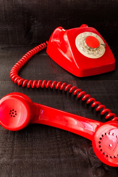 Ahşap arka plan üzerinde kırmızı retro telefon — Stok fotoğraf