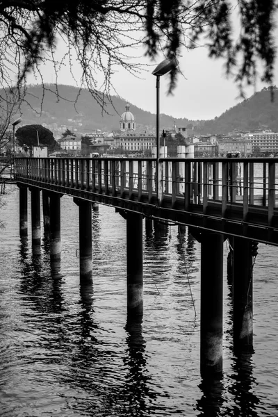 Pilares de cais em frente à paisagem de Como — Fotografia de Stock