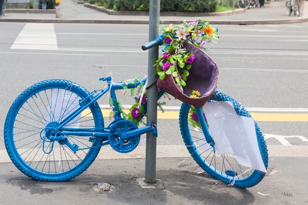 Blue bicycle with flowers for advertising in Milan Royalty Free Stock Photos