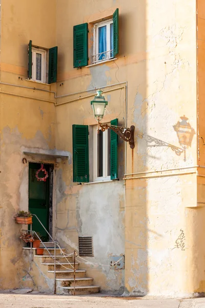 Shutters and door on ancient mediterranean facade with a lamp po — Stock Photo, Image