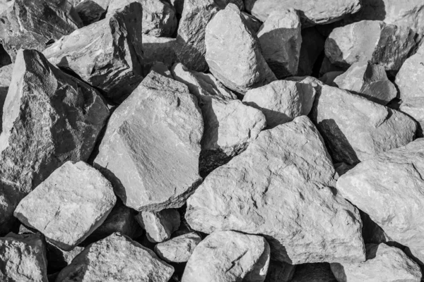 Large natural stones piled up in the bright sun in black and white — Stock Photo, Image