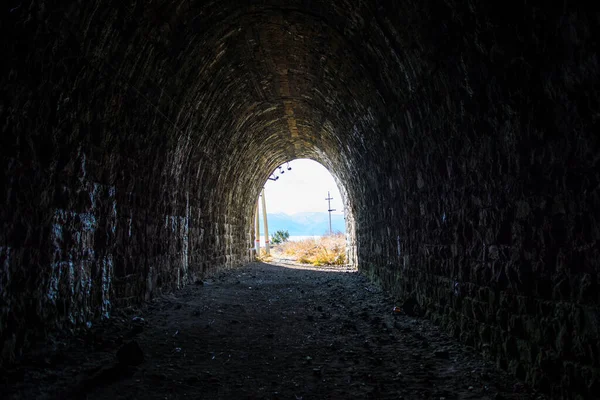 Exit from the dark railway tunnel. Exit from the dark railway tunnel. A light in the end of a tunnel.