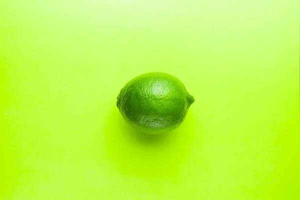 Fresh bright green lime on a green background.