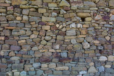 Eski taşlardan yapılmış kale duvarı. Tasarım ve fotoğraf arkaplanı için eski taş dokusundan yapılmış kale duvarı.
