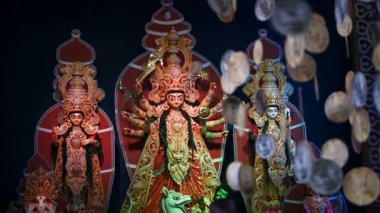 Durga Puja pandalını Durga idolüyle süslemiş, bozuk para asmış, Durga Puja festivali varmış. Renkli ışık altında yavaş çekim yapan HD görüntüler.