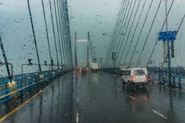 Batı Bengal, Kolkata 'daki 2. Hooghly Köprüsü olarak bilinen Ganj Nehri üzerindeki Vidyasagar Setu (Köprü). Soyut görüntü, her tarafında yağmur damlaları olan bir cam parçası, Kolkata 'nın muson resmi..