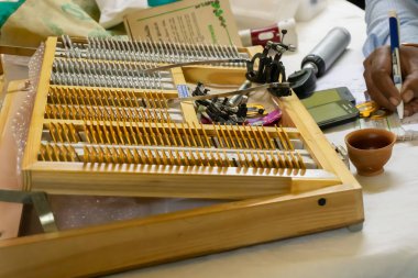 Kolkata, Batı Bengal, Hindistan - 25 Şubat 2018: Hintli erkek doktor Göz kontrolü kampında reçete yazıyor. Masasında göz testi için tıbbi aletler var..